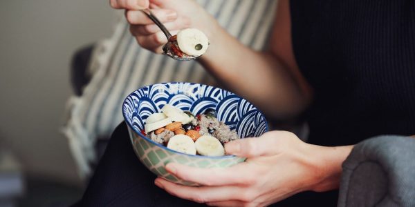 person holding spoon and bowl of food